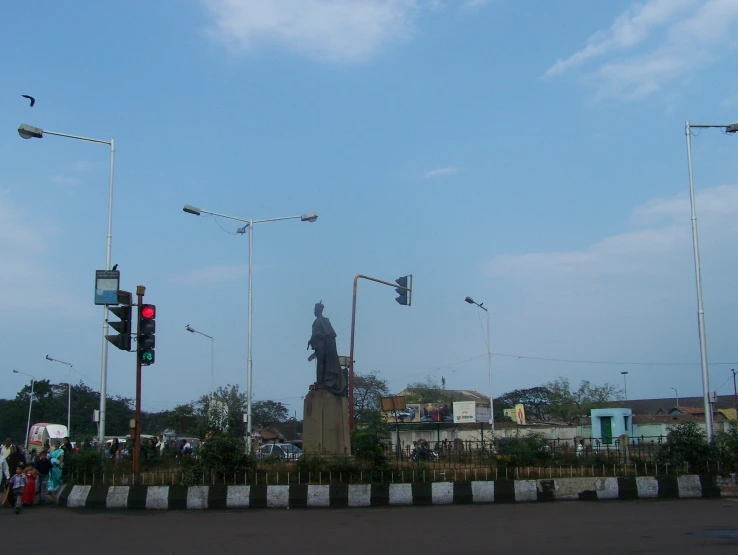 a large statue standing under three street lights