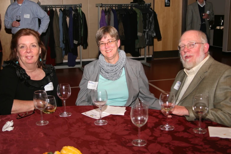 three people are sitting at a table together