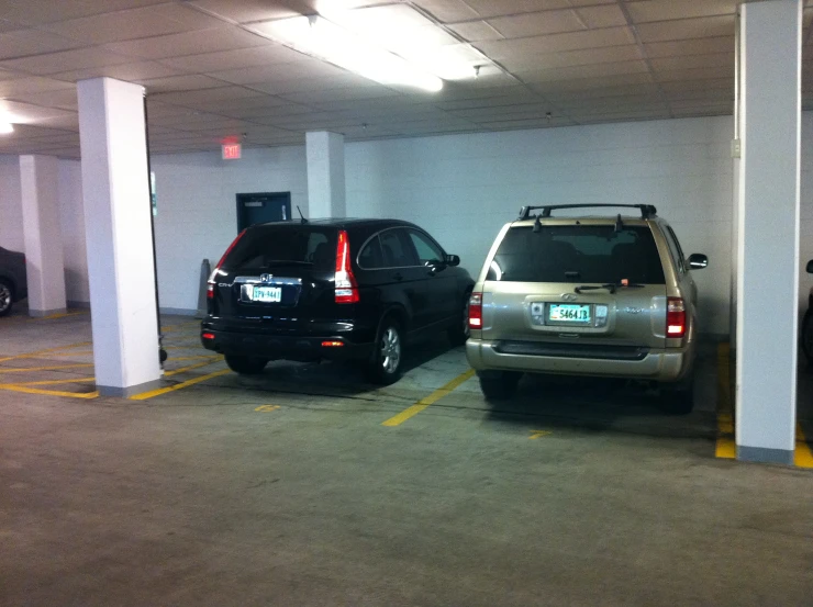 an indoor parking lot with parked cars in the area