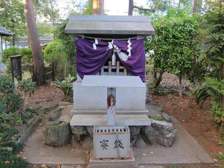 a concrete park bench with a purple cloth dd over it