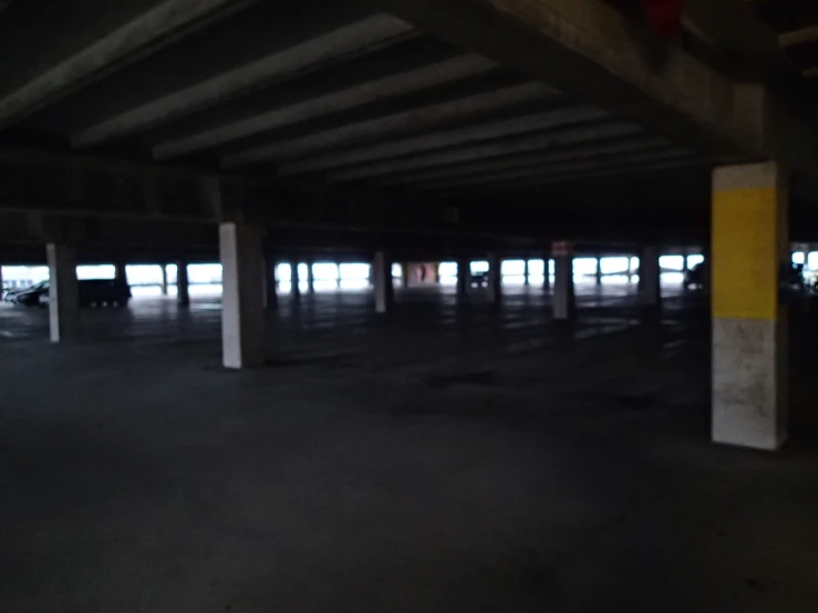 an empty parking garage with bright yellow and black columns