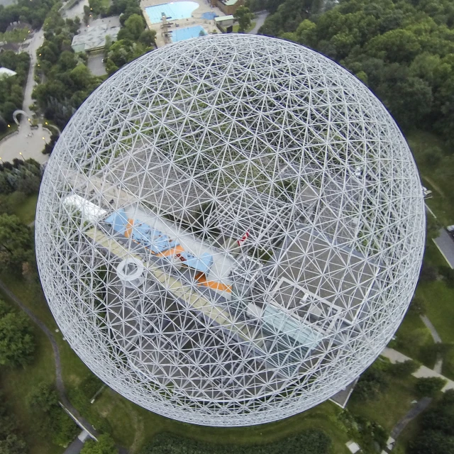 a large, white structure surrounded by trees and some water