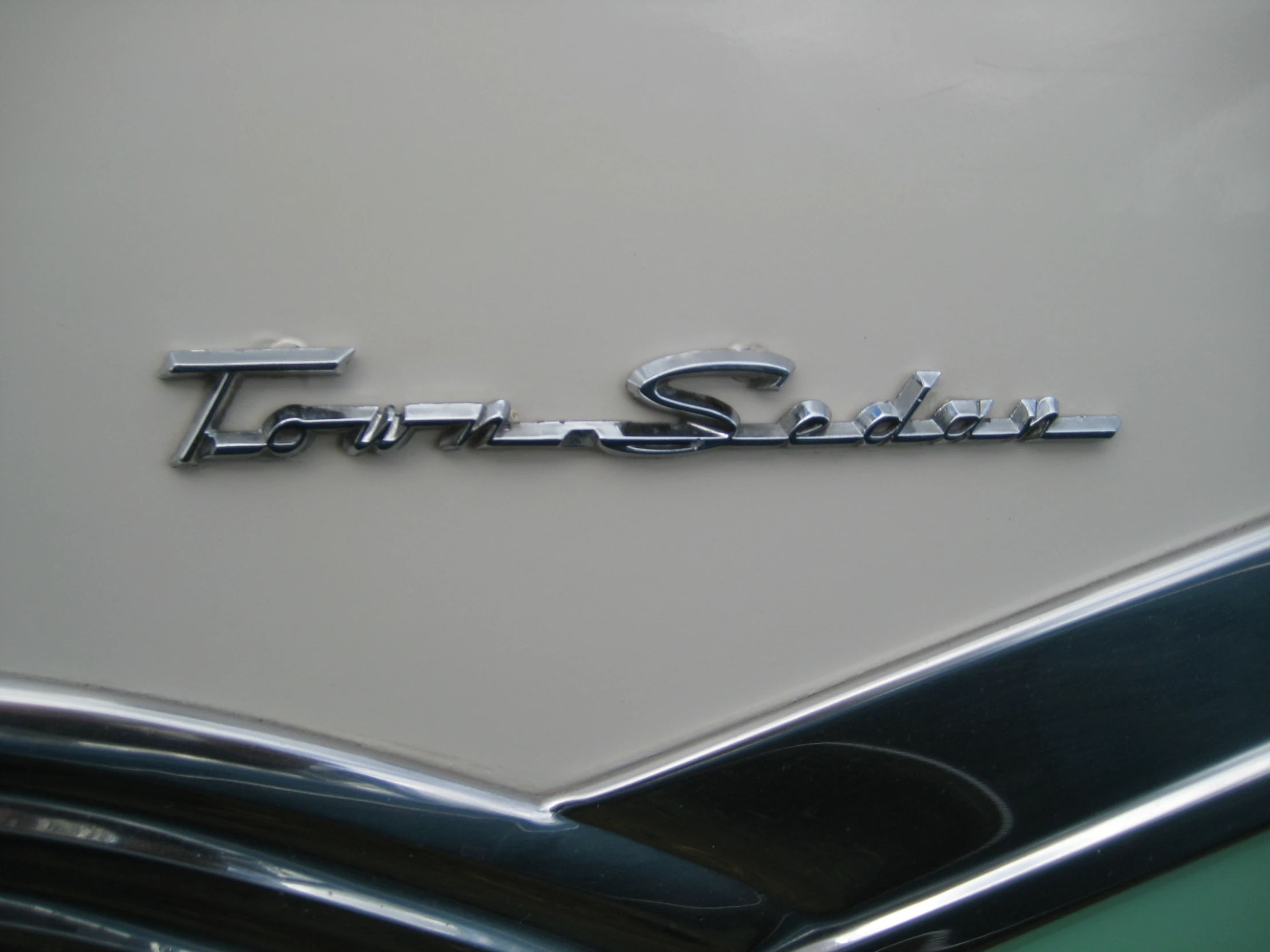 the emblem on a classic car with the letters ford in silver