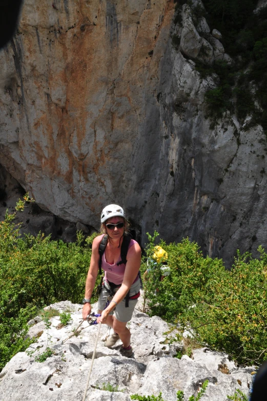 a woman is standing in the wilderness holding a stick