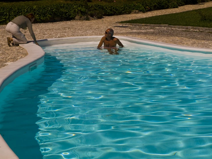 two people in a small pool with no water