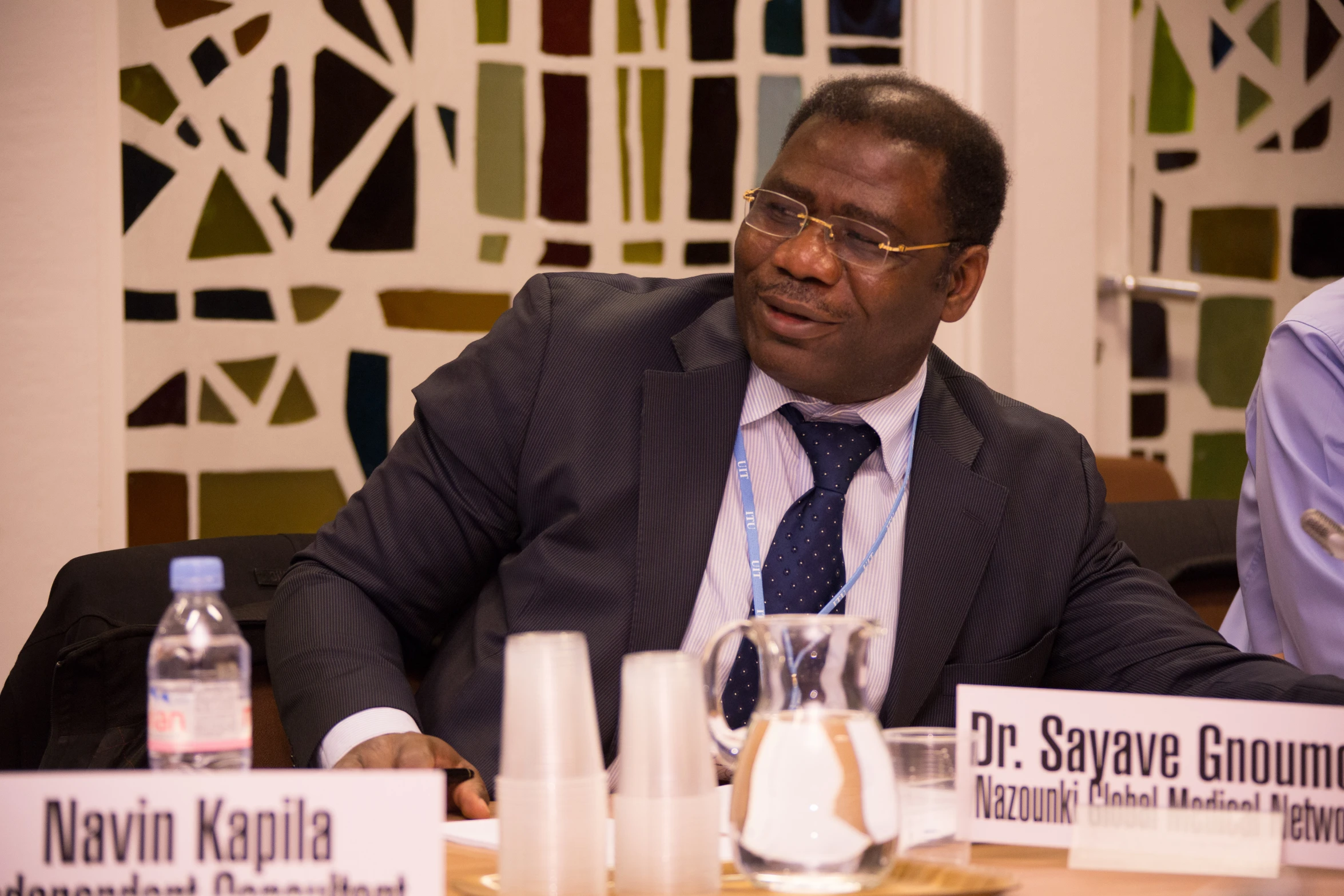 two men sitting at a table with a microphone