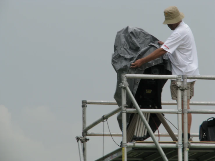 a man working on a ship under a gray sky