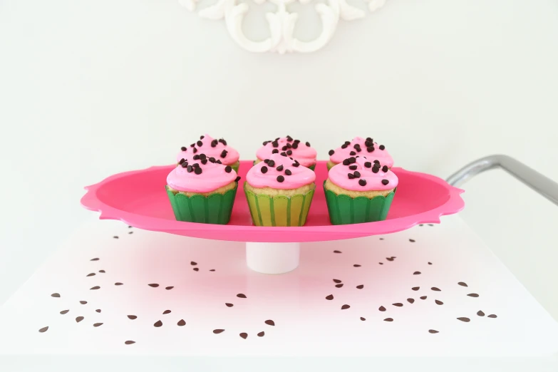 a table with a plate that has some cupcakes on it