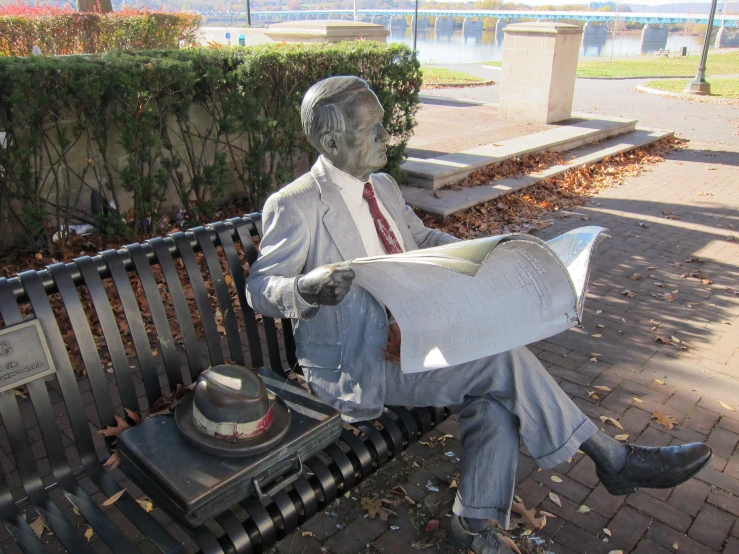 a person sitting on a bench and reading a newspaper