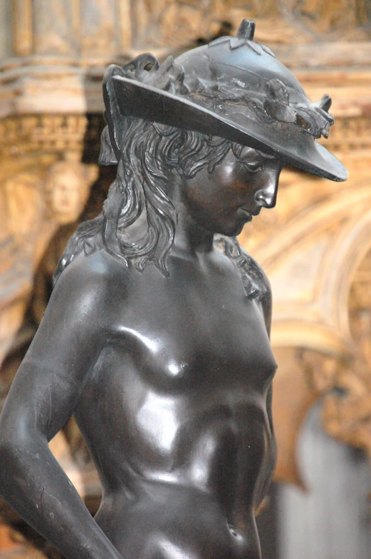 a statue wearing a hat next to a building