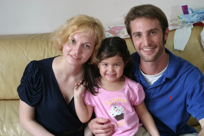 an adult and child sitting next to each other on the couch