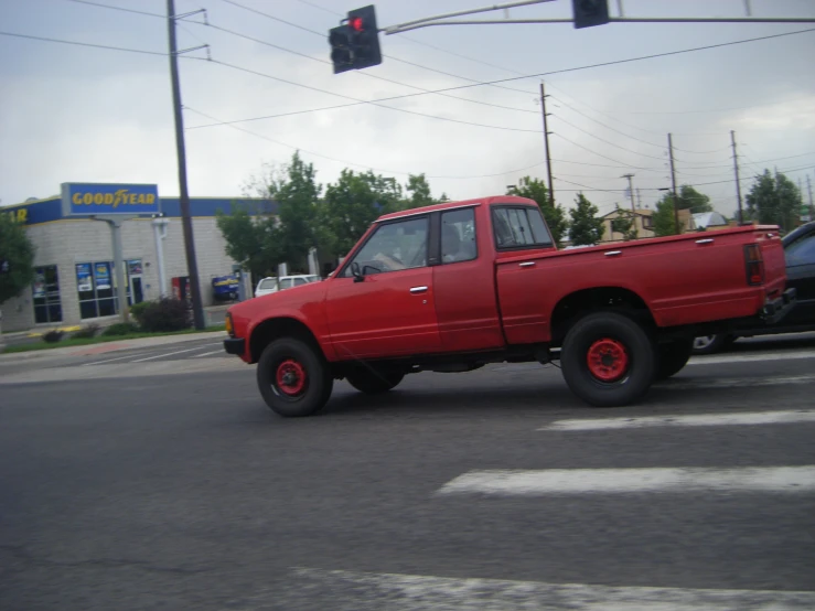 a red pick up truck parked on the side of a road