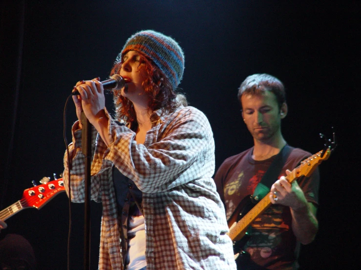 a musician with a blue plaid shirt and red guitar