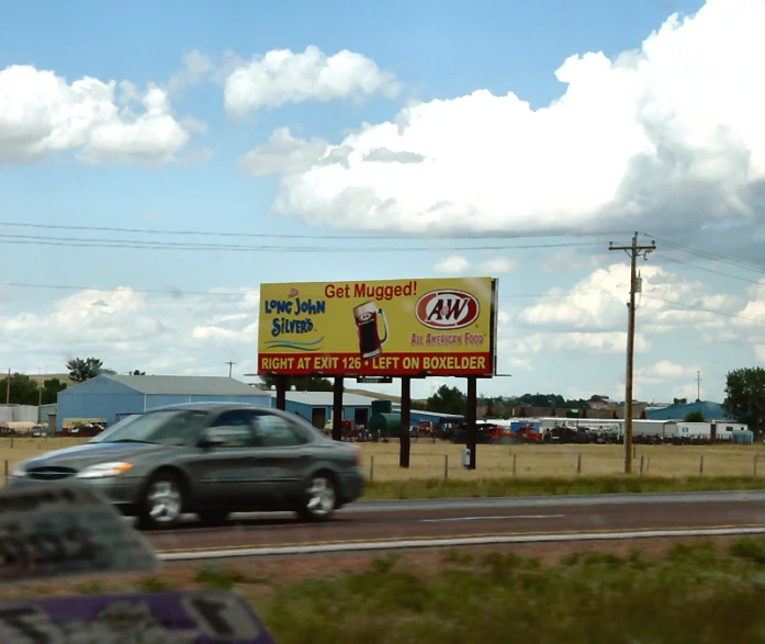 there is a sign on the side of a highway advertising liquor