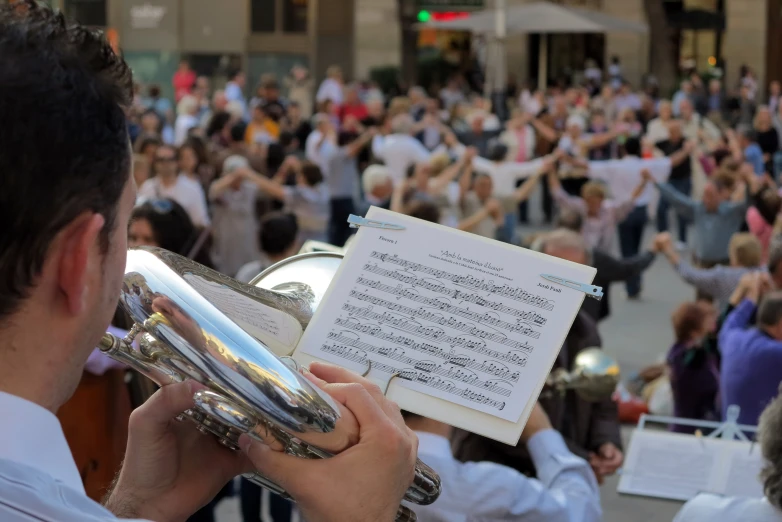 a man reads music outside with a trumpet