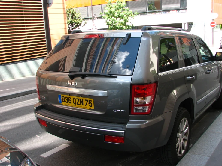 a grey vehicle parked next to a brick wall