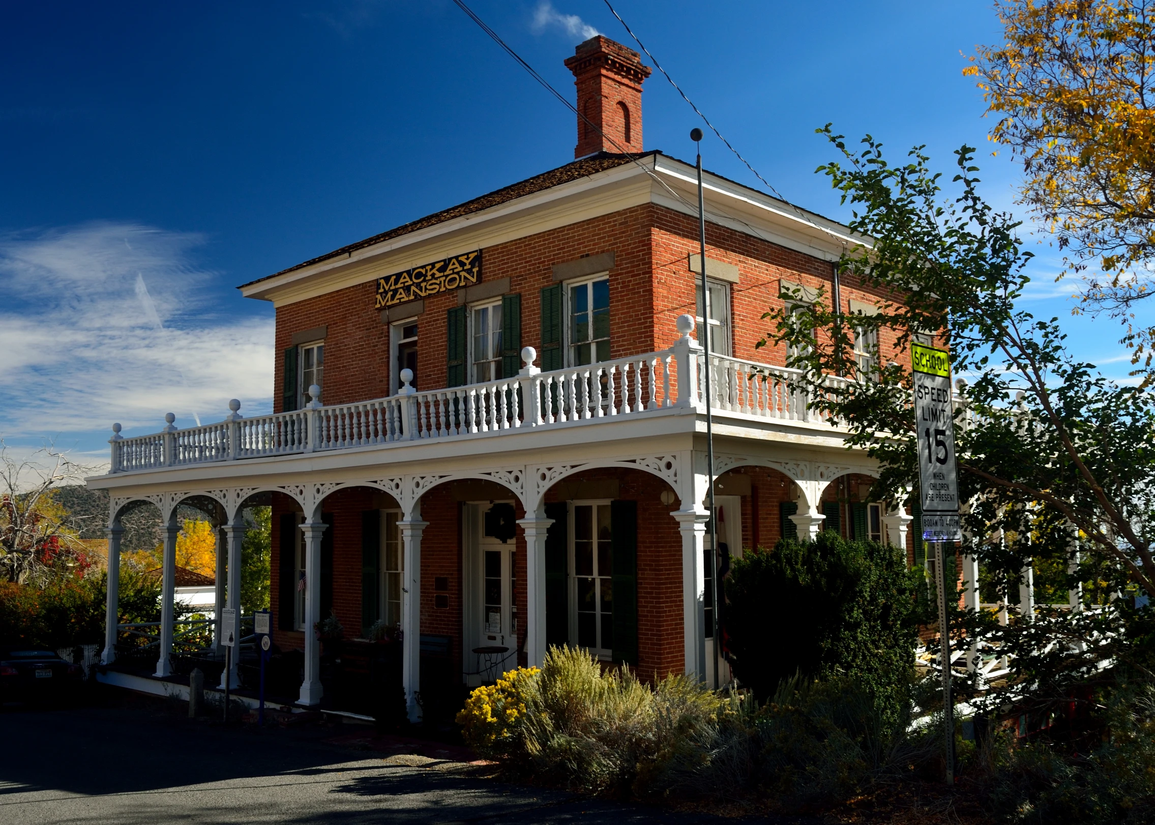 a red brick building with a white porch and many windows