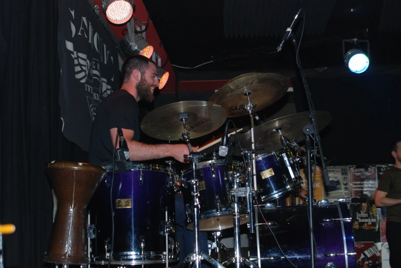 a man is playing drums in a band