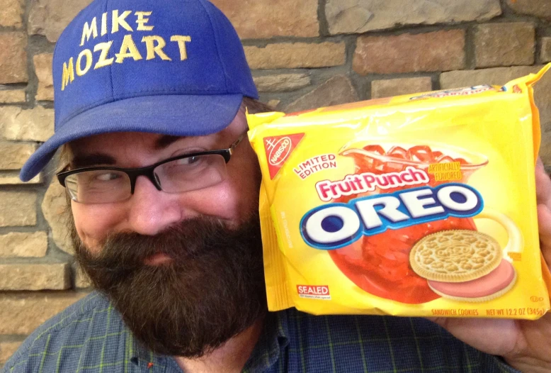 a bearded man is holding a bag of oreo