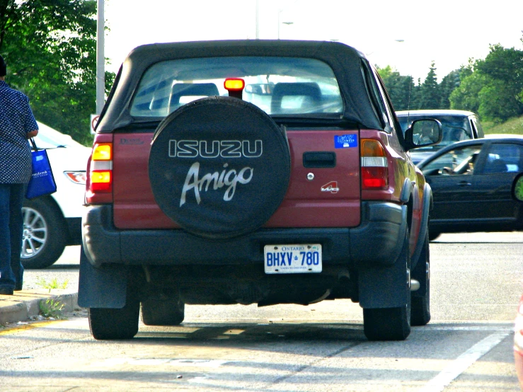 a red truck with some graffiti on it driving down the road