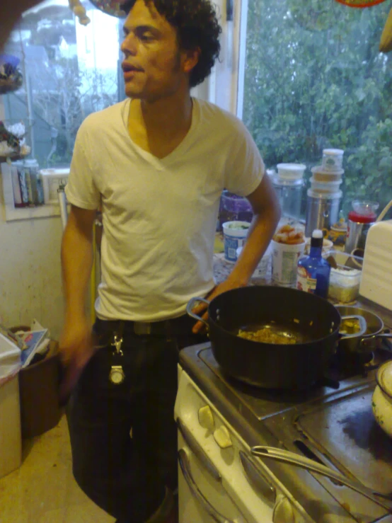 a young man is cooking on top of the stove