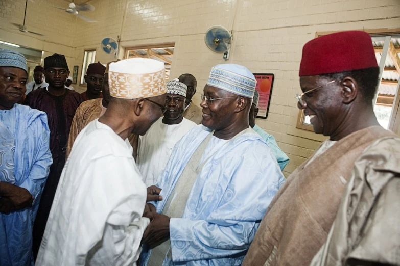 a group of men are standing around talking