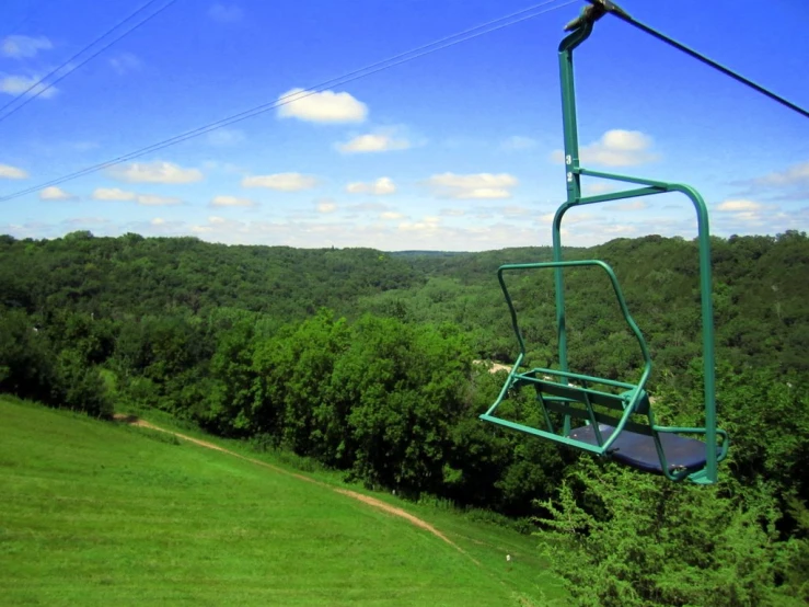 a person riding a gondola with trees below