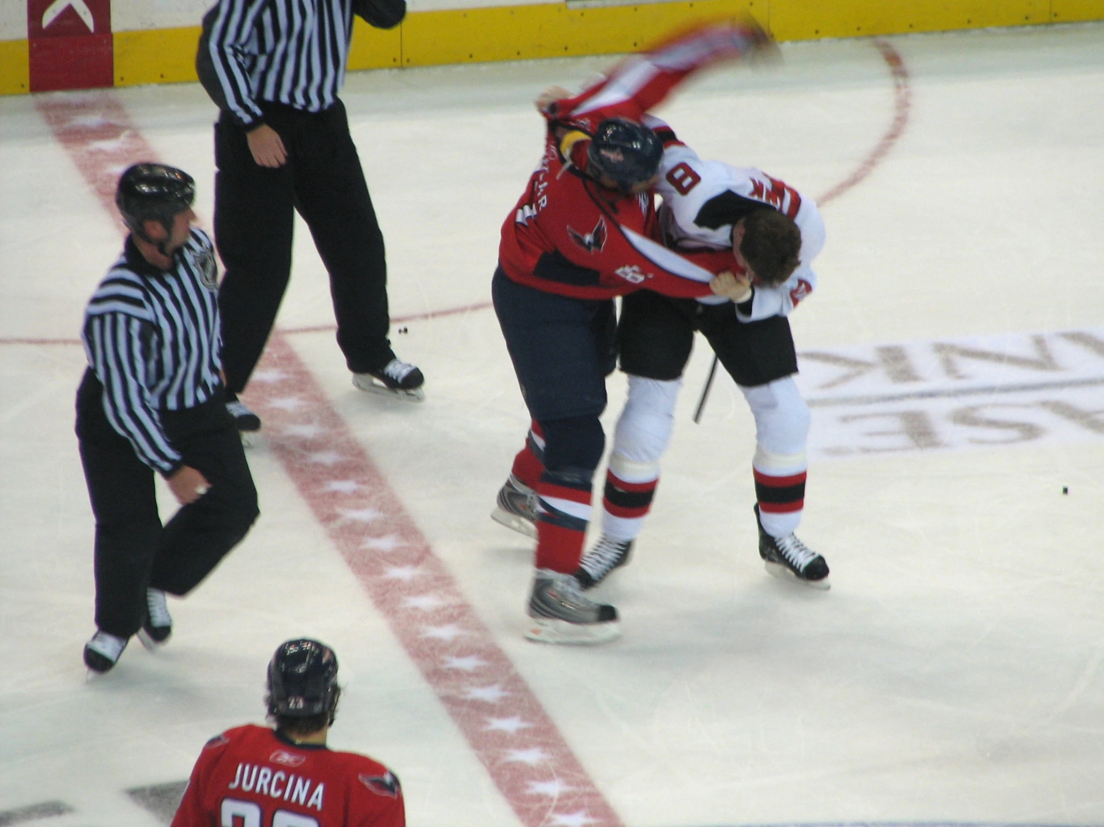 a hockey player about to hit the puck while being taken off