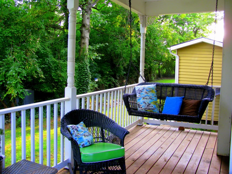 two wicker swing chairs and green chair on the deck