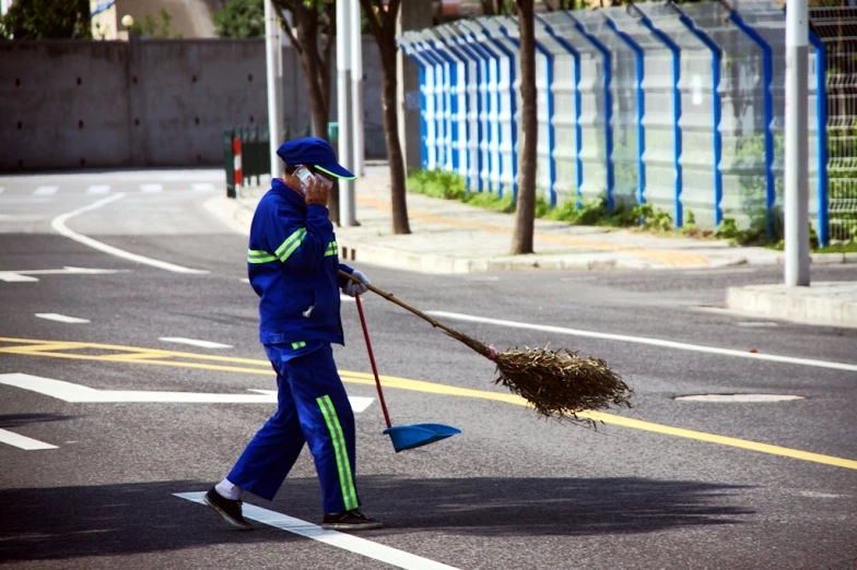 a person in a blue suit is holding a broom