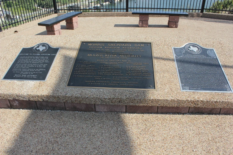 there are several plaques on the concrete near the fence