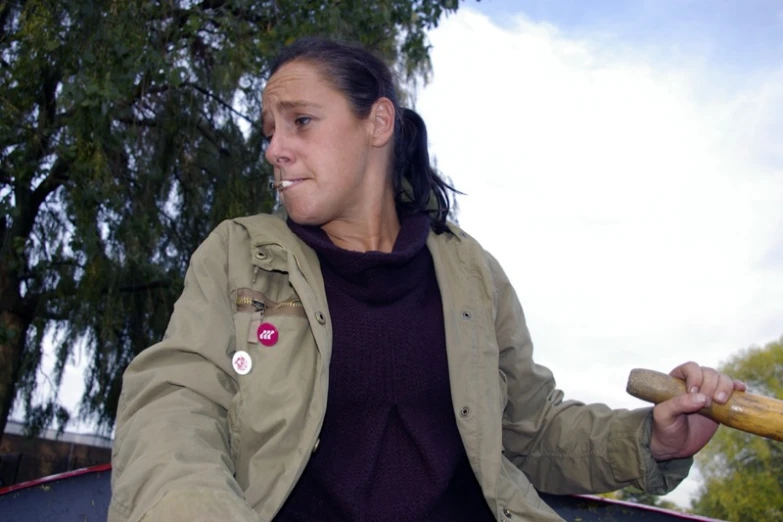 a woman sits and holds a baseball bat