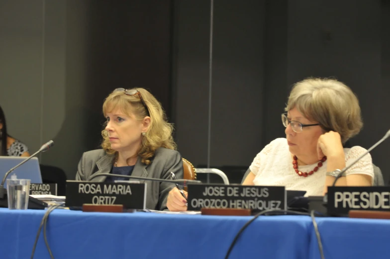 four people sitting at a table in front of microphones