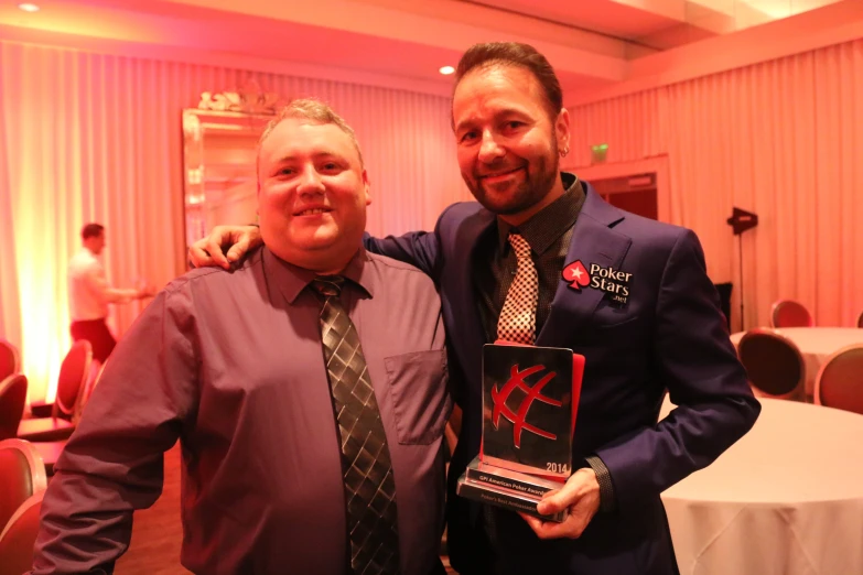 two men standing next to each other with an award