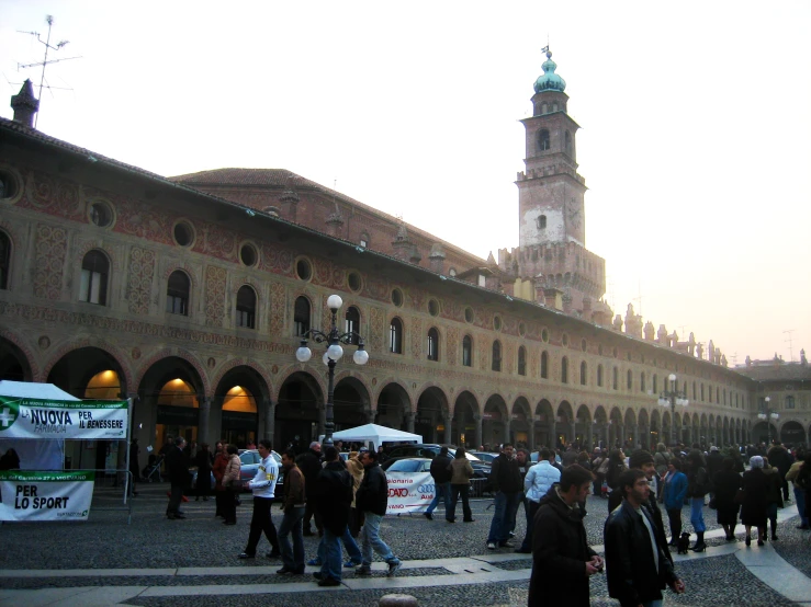 a group of people in a street with a large building