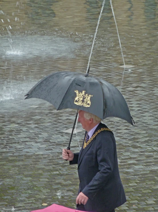 a man holds up an umbrella while walking through flood waters