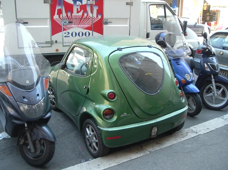 small car in front of motorcycle with trailer behind it