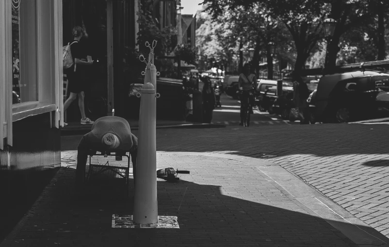 a fire hydrant next to a light pole on the sidewalk