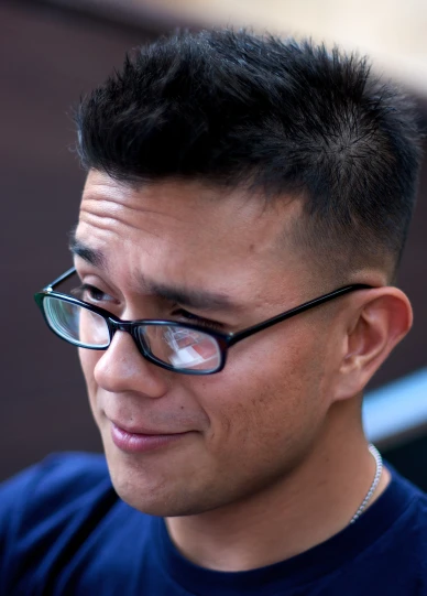 a man in glasses stares sideways into the camera