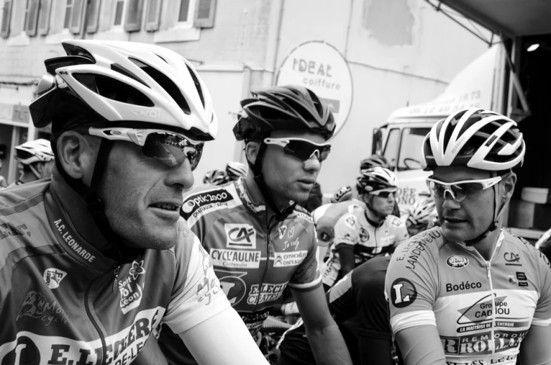 men riding bicycles together while wearing helmets