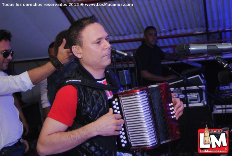 a man playing the accordion in front of a microphone