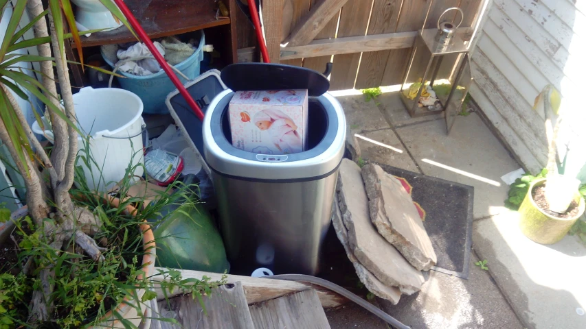 a garbage can with some boxes and other items outside