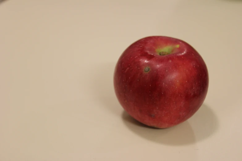 an apple sitting on top of a white table