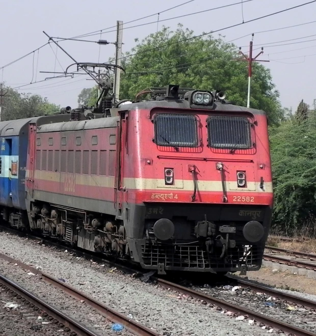 an old red train is riding down the railroad tracks