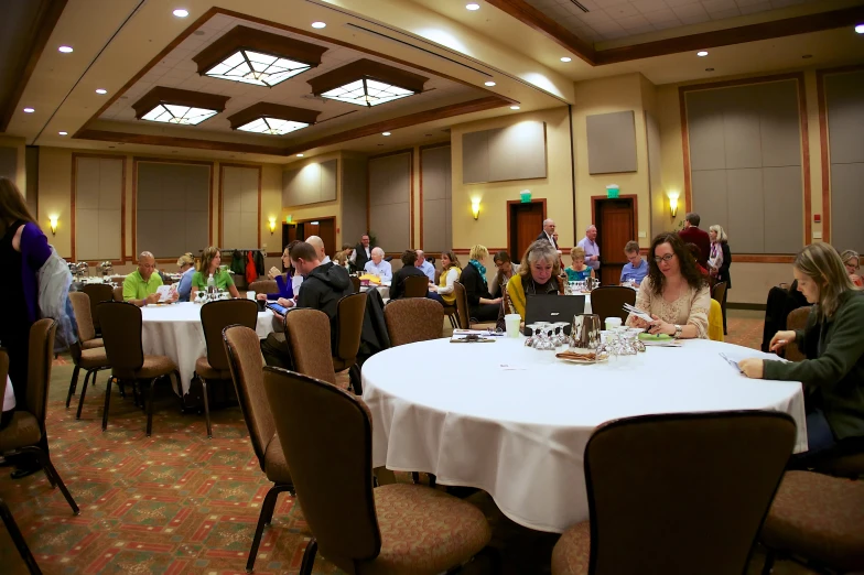 a meeting room with people seated at tables