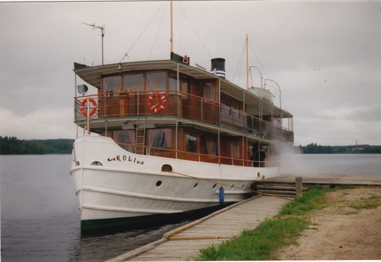 a boat is anchored at the dock by some water