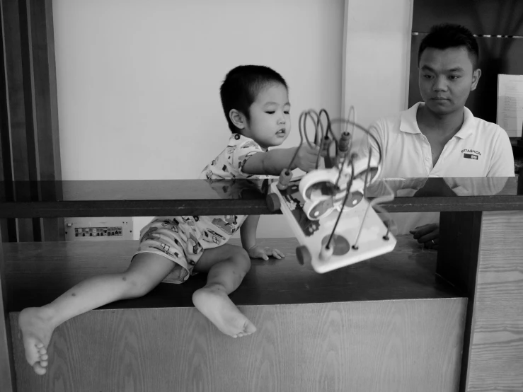 a boy is sitting with an electric toy in his hands