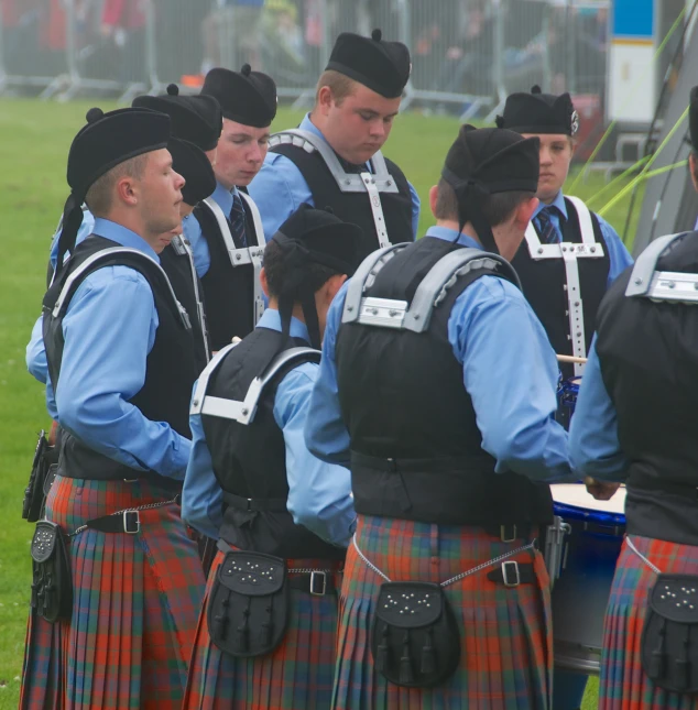 a group of people dressed in kilts and dresses