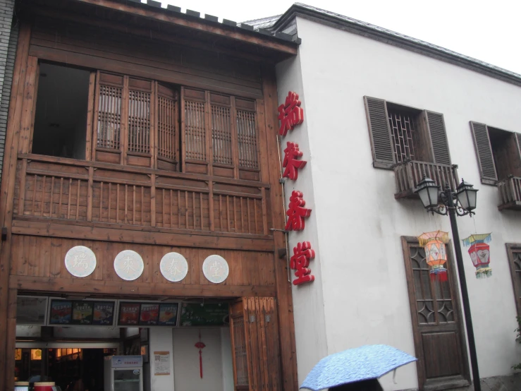 a person walking past a building with several chinese decorations on it