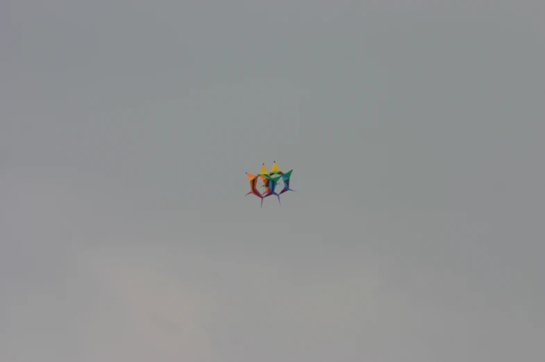 two kites that are in the sky with people underneath them